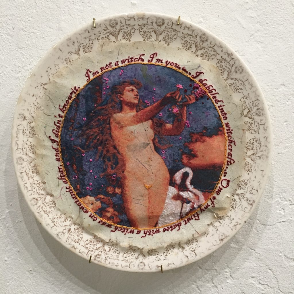 GINI HOLMES
I am not a witch, 2017
Heat transfer on handmade paper, embroidery, ink, flocking, dinner plate
$207

Quote: “I’m not a witch… I’m you.” ~ Christine O’Donnell, in a 30 second ad responding to a video clip from a 1999 appearance in Bill Maher’s “Politically Incorrect”, in which she said, “ dabbled into witchcraft I never joined a coven. But I did, I did… I dabbled into witchcraft. I hung around people who were doing these things. I’m not making this stuff up. I know what they told me they do… One of my first dates with a witch was on a satanic altar, and I didn’t know it. I mean, there’s little blood there and stuff like that. We went to a movie and then had a midnight picnic on a satanic altar.”

Image: Hymn To The Creator