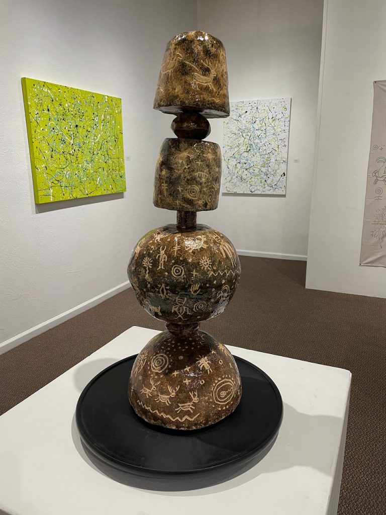 Lucky Preston, "Totem", 2021 , clay, slab formed hollow globes,  
24.5” h x 7” w, This spinnable sculpture is adorned with many images of petroglyphs found on rocks and in caves worldwide. Deer, sheep, insects, human forms, stars and planets are depicted, which were important to them.
